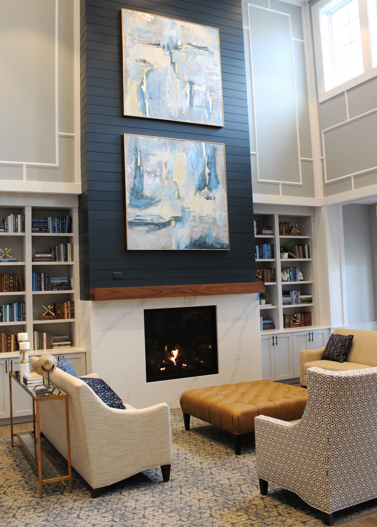 A cozy living room with a modern fireplace, abstract artwork, and built-in bookshelves.