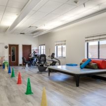 A physical therapy room with various exercise equipment and colorful cones.