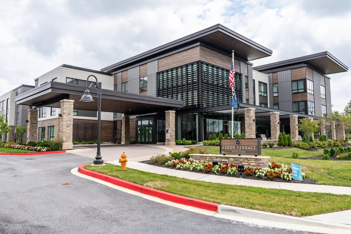 A modern building with large windows and a landscaped entrance.