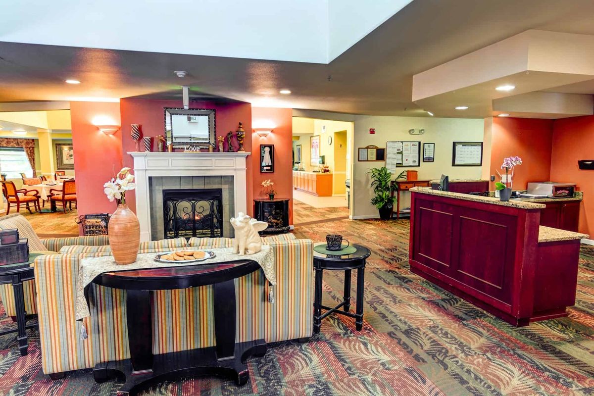 A cozy lobby area featuring a fireplace, decorative elements, and a reception desk.