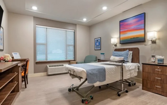 A clean and well-designed hospital room with a patient bed and modern decor.