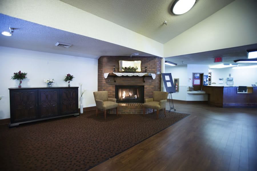 A cozy hotel lobby with comfortable chairs and a warm fireplace.