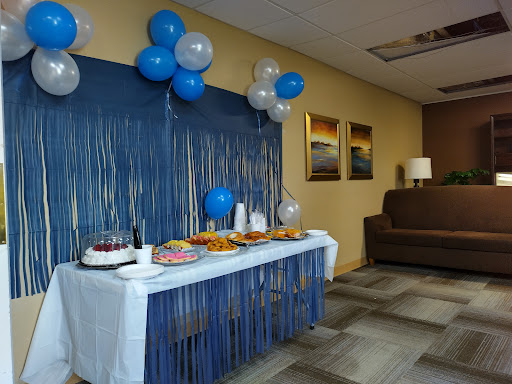 A festive setup featuring a table adorned with treats and blue balloons, perfect for a celebration.