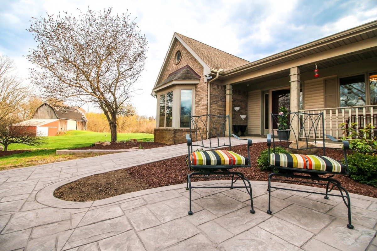 A suburban house with a landscaped patio and outdoor seating.