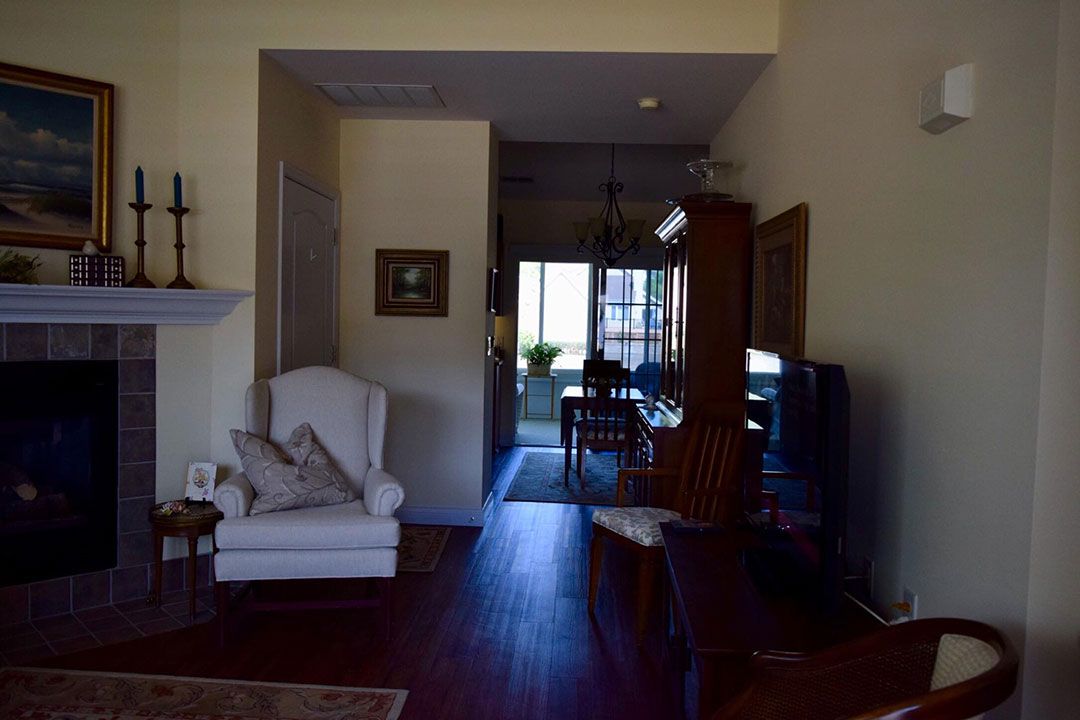 A cozy living room leading into a dining area with hardwood flooring.
