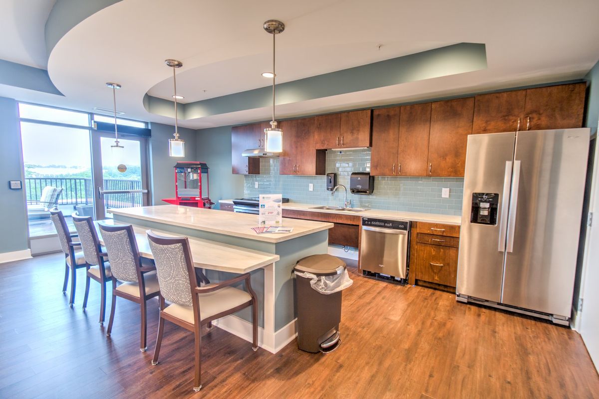 A modern kitchen with wooden cabinets, stainless steel appliances, and a spacious island with seating.