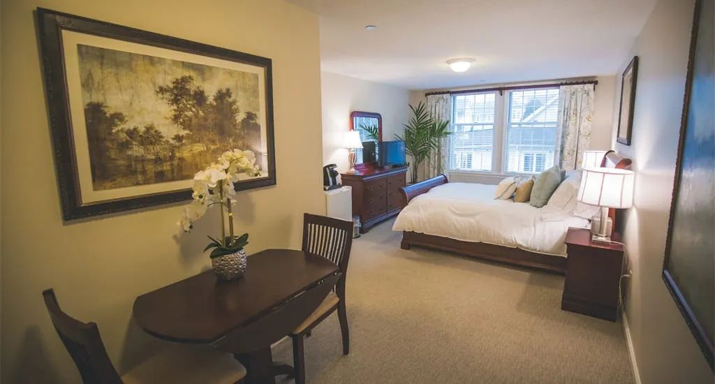 A cozy and tastefully decorated bedroom with a bed, table, and indoor plant.