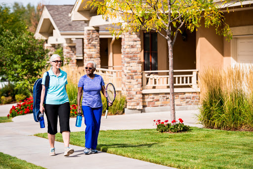 Two friends enjoying a walk in their neighborhood, promoting an active lifestyle.
