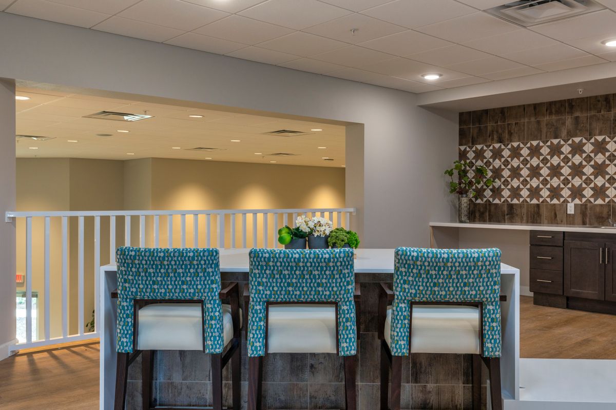 A modern kitchen interior featuring a countertop with stylish chairs and contemporary decor.