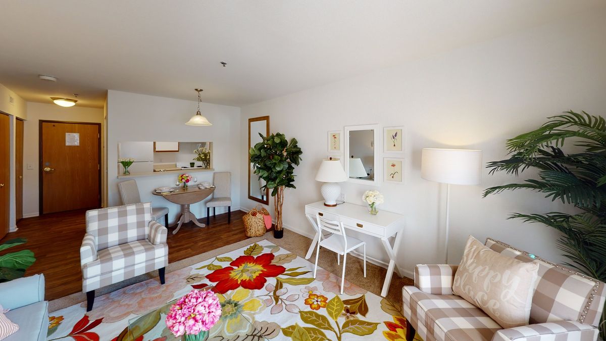 A cozy living room with floral decor and comfortable seating.