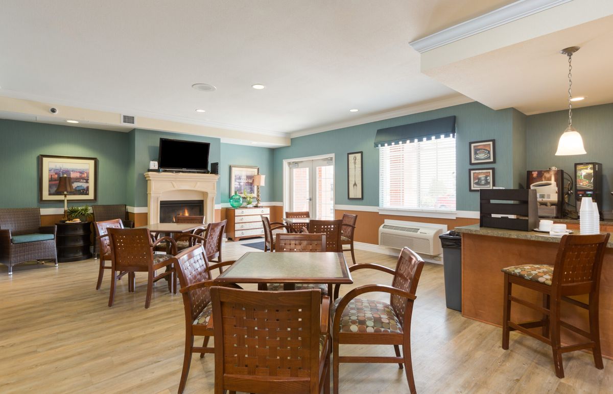 A cozy dining area featuring wooden furniture, a fireplace, and a television.