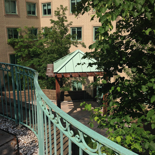 A view of a garden area featuring a gazebo and surrounding greenery, framed by a decorative railing.