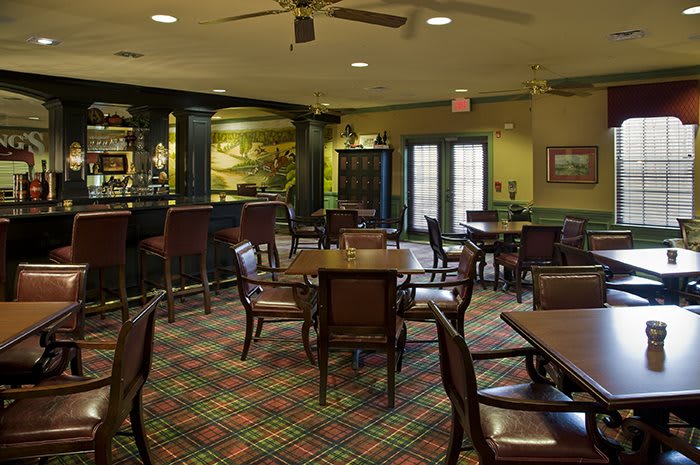 An empty restaurant interior with a bar and various seating arrangements.