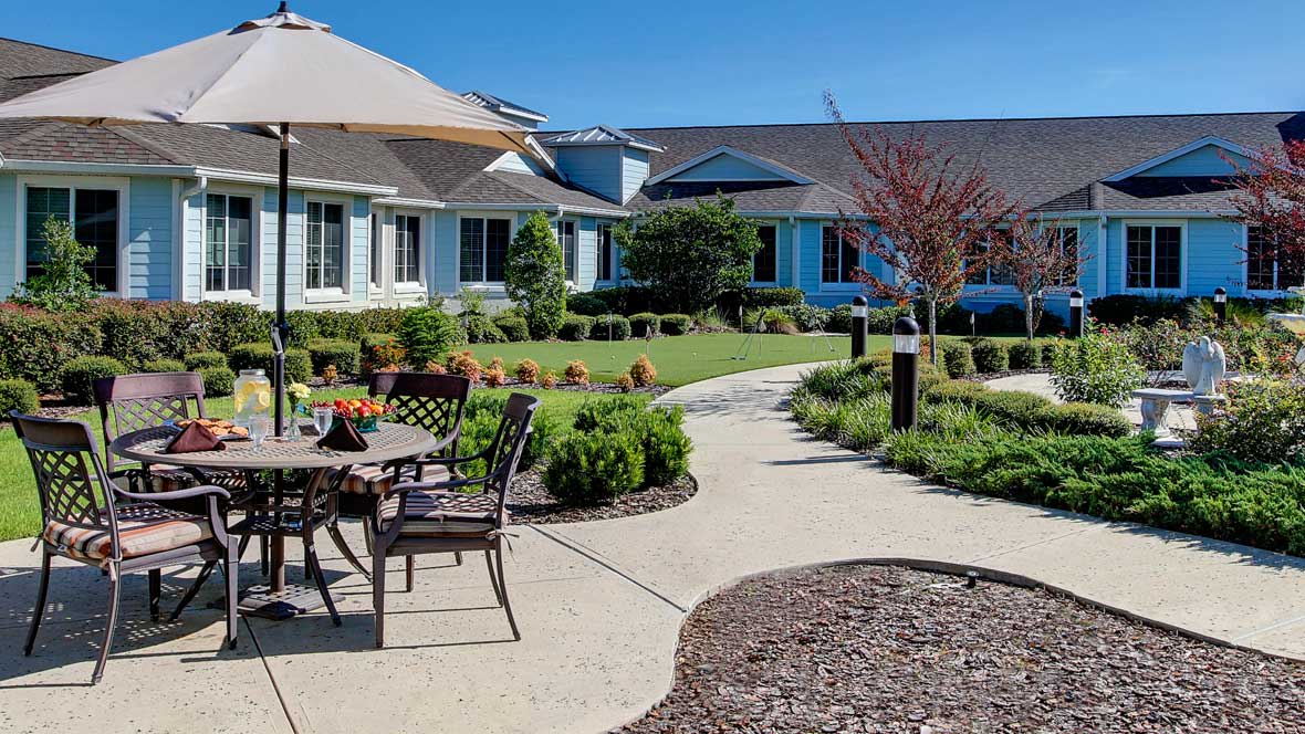 A beautifully landscaped residential garden with a patio and outdoor seating.
