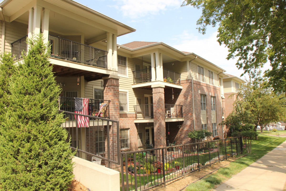 A multi-story apartment building with balconies and surrounding greenery.