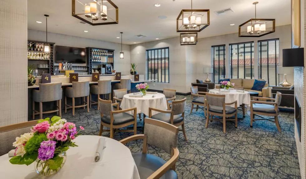A cozy restaurant dining area with elegantly set tables and modern lighting.