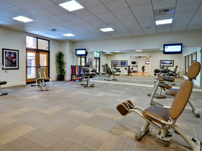 A modern gym with exercise equipment and mirrors.
