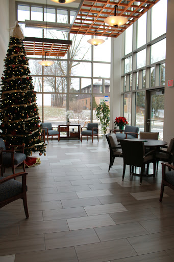 A cozy and modern lobby decorated for the holiday season, featuring a beautifully adorned Christmas tree.