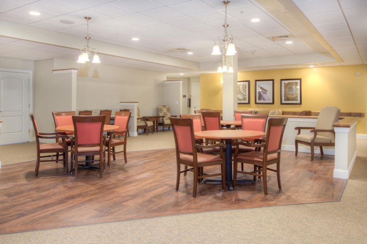 A well-lit dining area with multiple tables and chairs, featuring elegant decor.