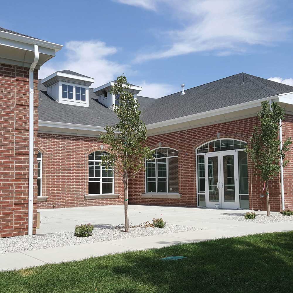 A modern brick building with large windows and a well-maintained landscape.