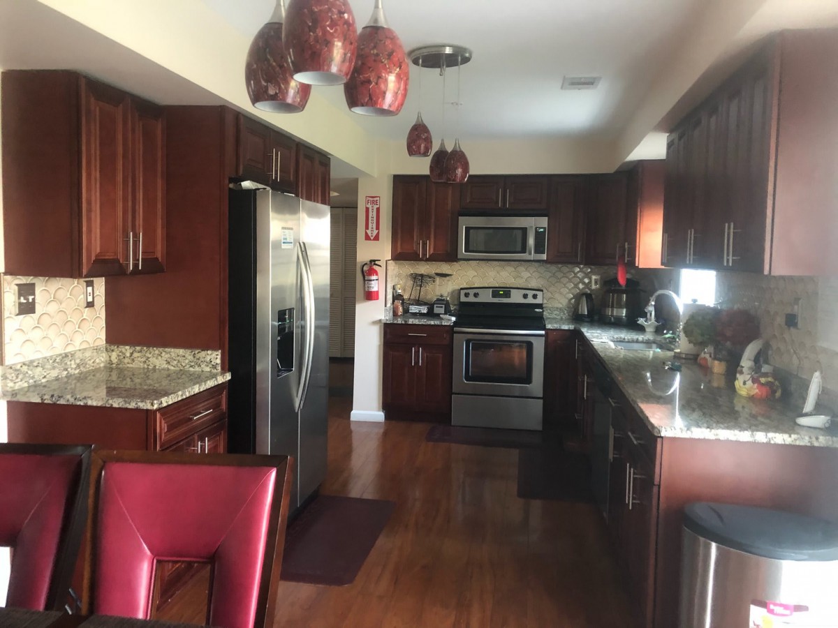 A modern kitchen with stainless steel appliances and wood cabinets.