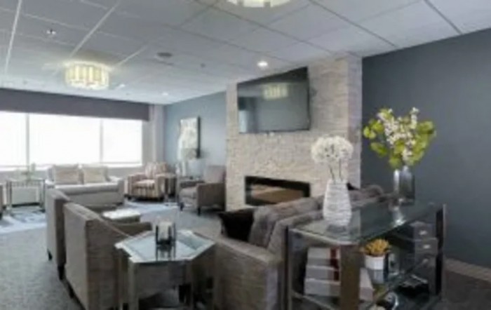 A modern living room with a fireplace and television, featuring comfortable seating and elegant decor.