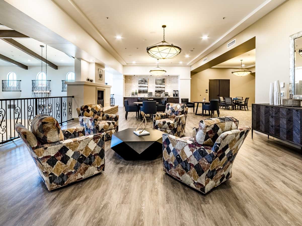 A spacious and elegantly designed living room with modern furniture and chandeliers.