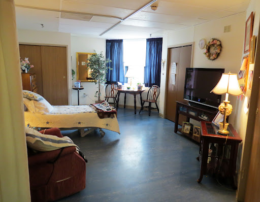 A cozy and well-furnished room featuring a bed, seating area, and a dining table.