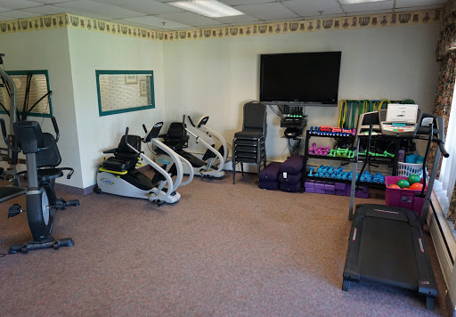 A well-equipped fitness room featuring exercise machines and weights.