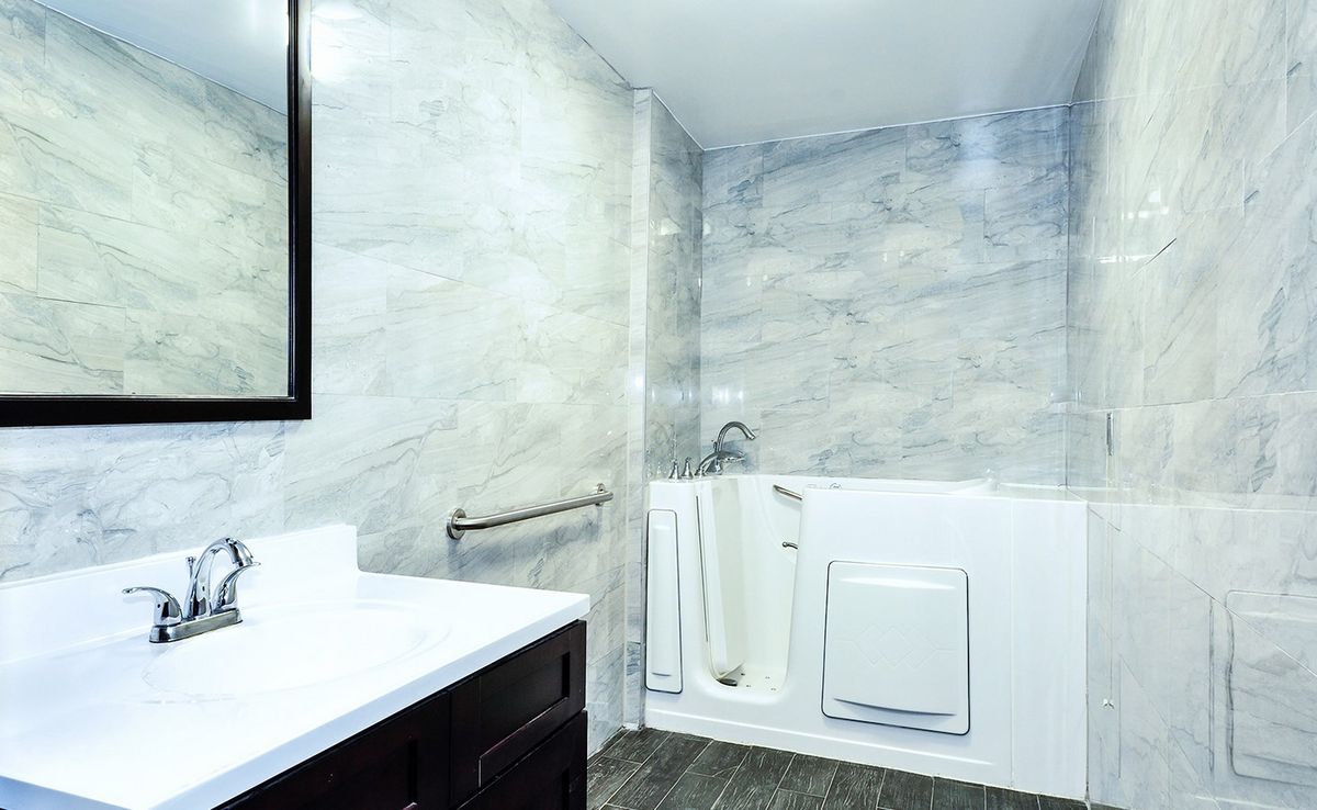 A modern bathroom featuring a walk-in bathtub with safety features.