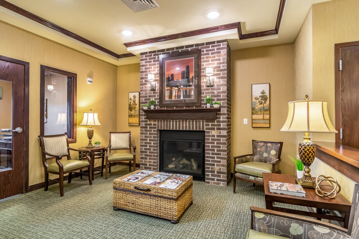 A cozy living room with a brick fireplace, surrounded by comfortable seating and warm lighting.