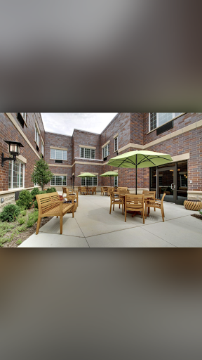 A cozy courtyard featuring wooden furniture and umbrellas, perfect for outdoor relaxation.