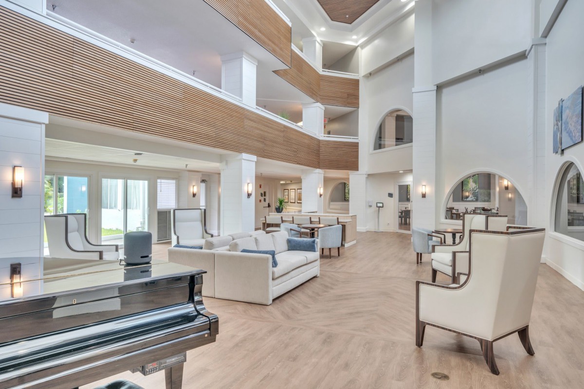 A spacious and luxurious living room with modern furniture and a grand piano.