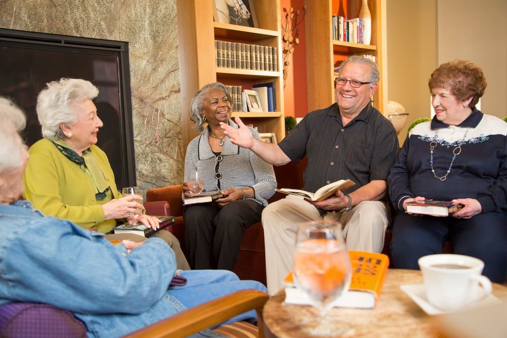 A group of elderly people enjoying a lively discussion at a book club meeting.