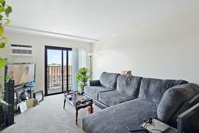 A bright and cozy living room with a comfortable sofa, coffee table, and access to a balcony.