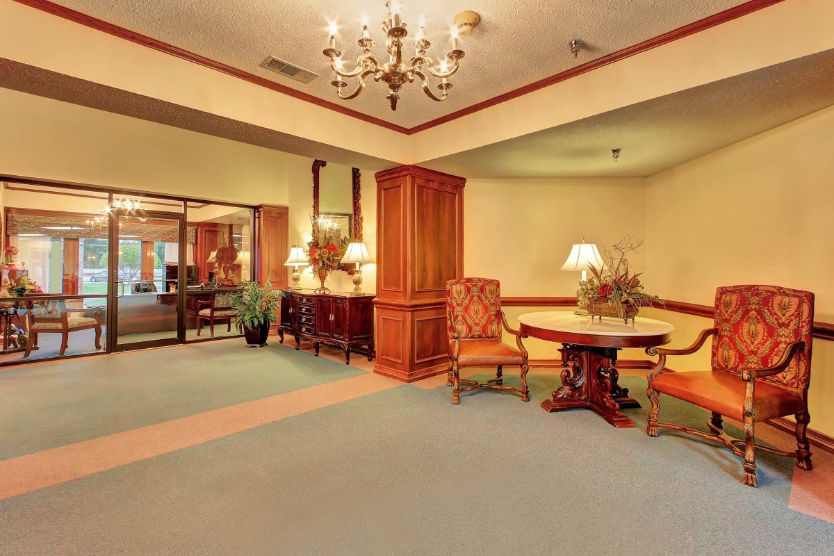A warmly decorated hotel lobby with traditional furnishings and a chandelier.