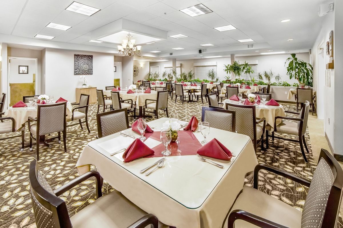 An elegant indoor dining area with neatly arranged tables and red napkins.