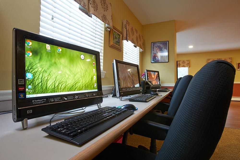 A row of computers set up in a brightly lit office space.