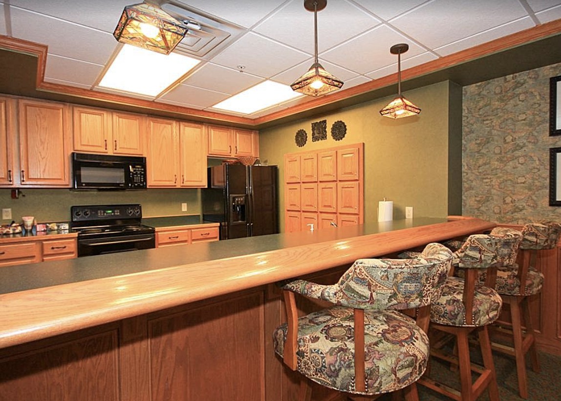 A warm and inviting kitchen with wooden cabinetry and decorative hanging lights.