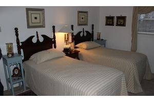 A cozy bedroom featuring twin beds with wooden headboards and decorative elements.