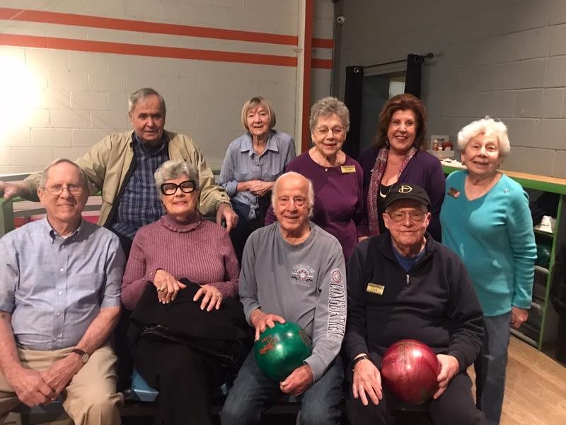 A group of seniors enjoying a day at the bowling alley.
