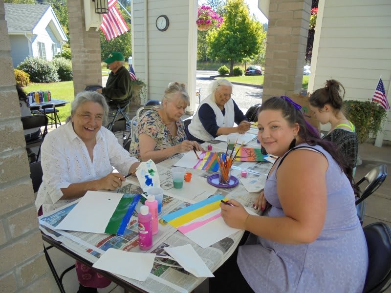 A group of people enjoying an outdoor painting activity together.
