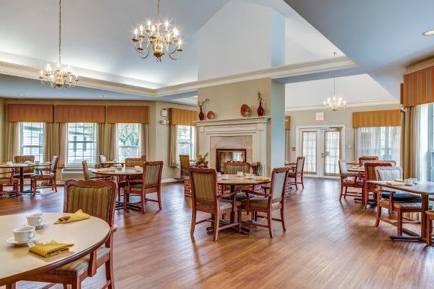 A cozy dining area with elegant lighting and classic wooden furniture.