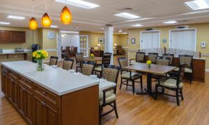 A cozy dining area with multiple tables and chairs, warm lighting, and a welcoming atmosphere.