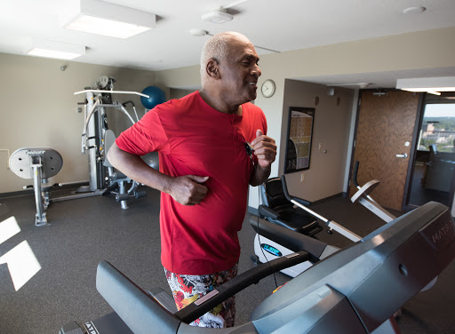 A person jogging on a treadmill in a gym setting.