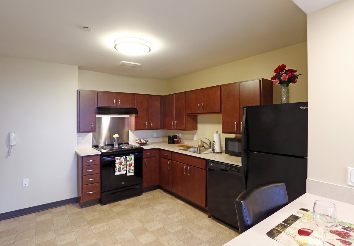 A modern kitchen with wooden cabinets and standard appliances.