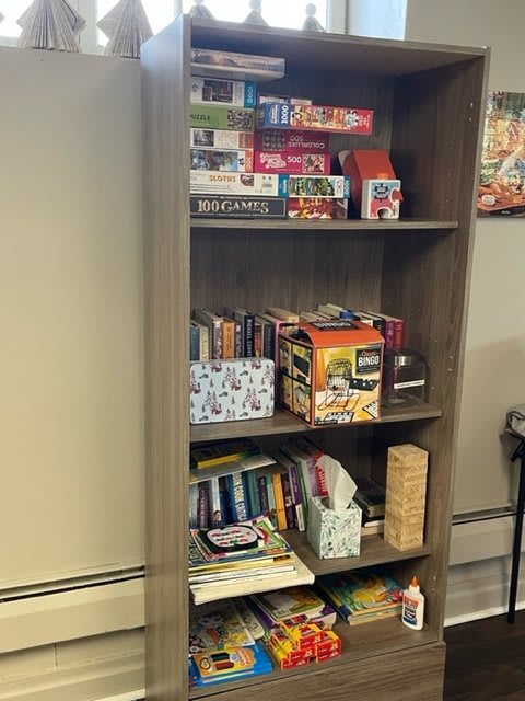 A bookshelf filled with board games and books.