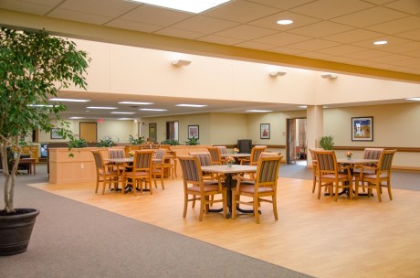 A spacious dining area with wooden tables and chairs, creating a warm and inviting atmosphere.