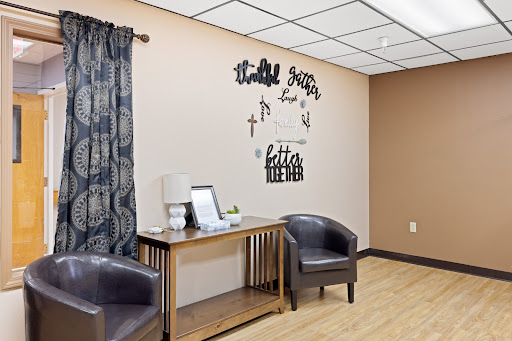 A cozy waiting area featuring stylish chairs and decorative wall art.