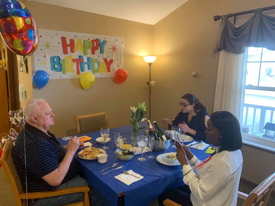 A small group of people enjoying a birthday celebration with decorations and food.
